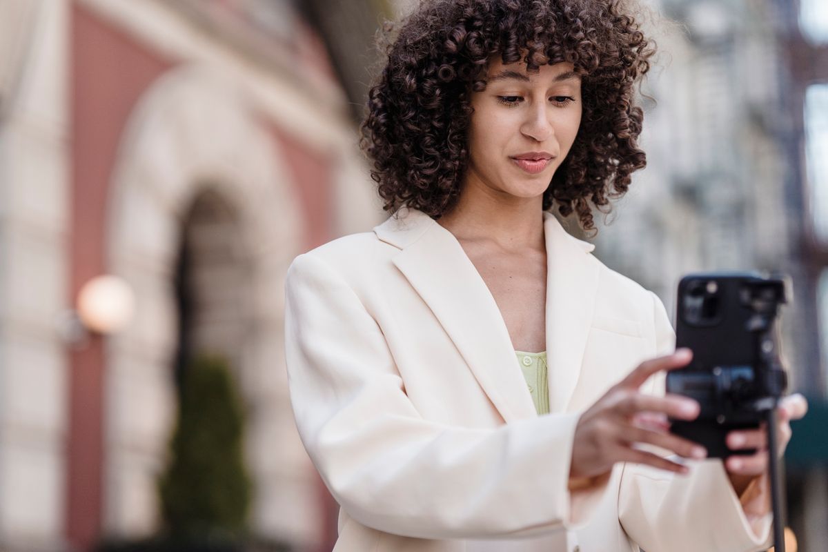 A creator filming herself with a phone on a city street